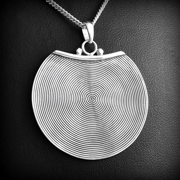 Superbe pendentif en argent d'un disque ornée d'une spirale en relief (diam.:34mm).