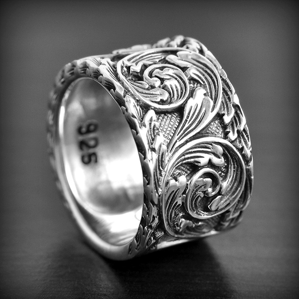 Bague anneau massif en argent magnifiquement ciselé de motifs floraux, une petite partie lisse...