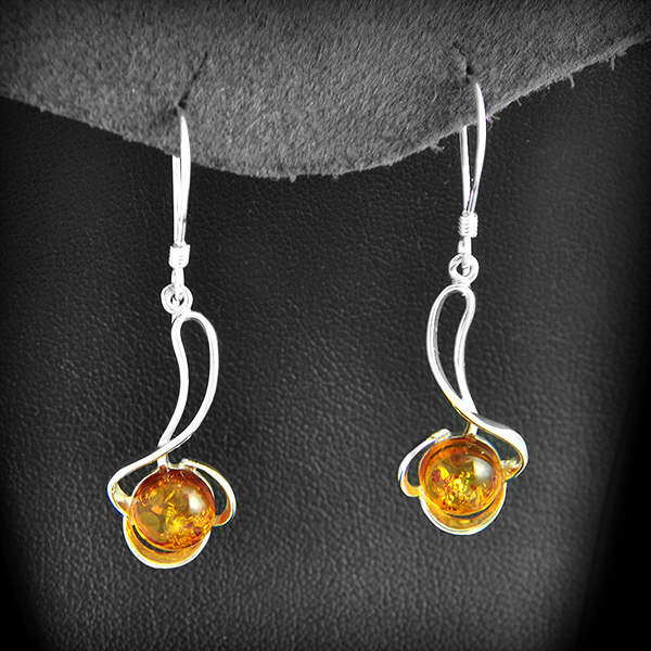 Paire de boucles d'oreilles pendantes en argent parées d'une perle d'ambre cognac (h:44mm).