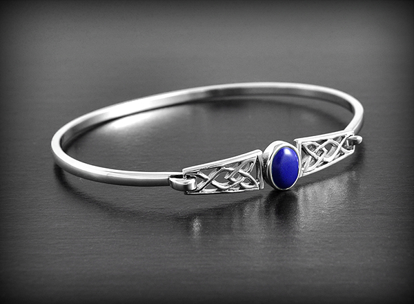 Joli bracelet en argent paré au centre d'une pierre de lapis lazuli en cabochon et orné...