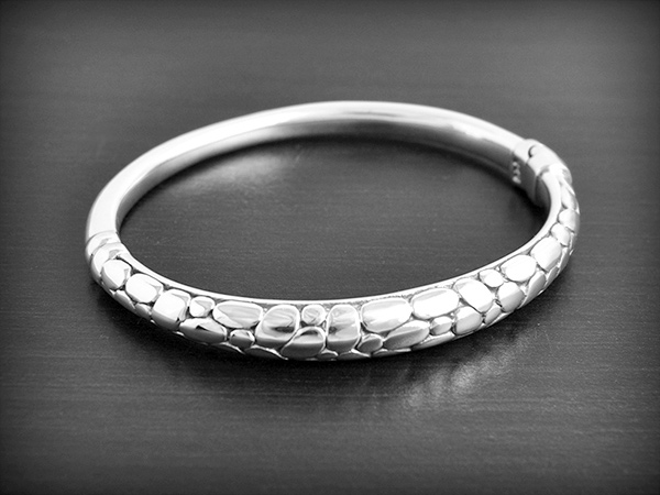 Joli bracelet en argent  décoré sur le dessus façon écaille de serpent, C'est un modèle creux et...