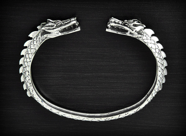 Magnifique bracelet rigide en argent orné de deux têtes de dragons aux extrémités et le corps en...