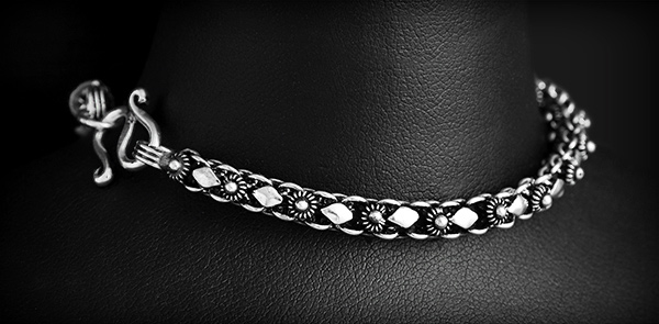 Joli bracelet en argent avec une maille décorée d'une rangée de petites fleurs de frangipanier...