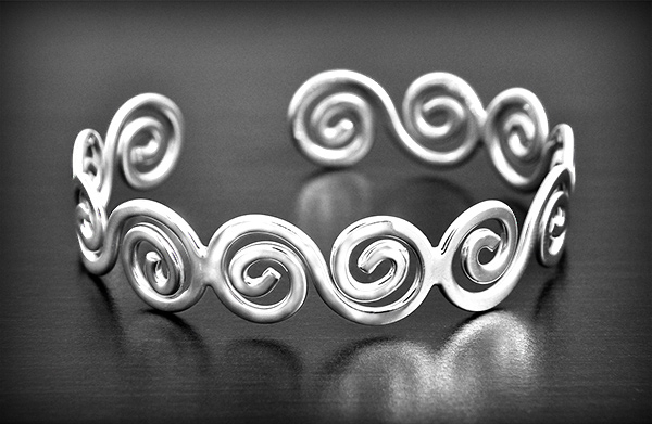 Bracelet rigide en argent en motif de vagues en spirales (h:13mm, L:18,5cm).