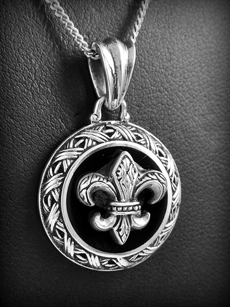 Pendentif en argent d'une médaille en émail noir décoré d'une fleur de lys ciselée avec une jolie...