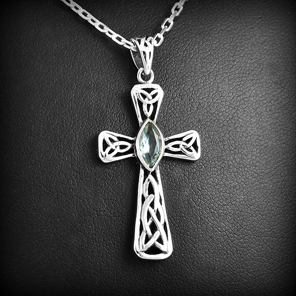 Joli pendentif en argent d'une croix celtique ajourée et orné d'une pierre de topaze bleue,...