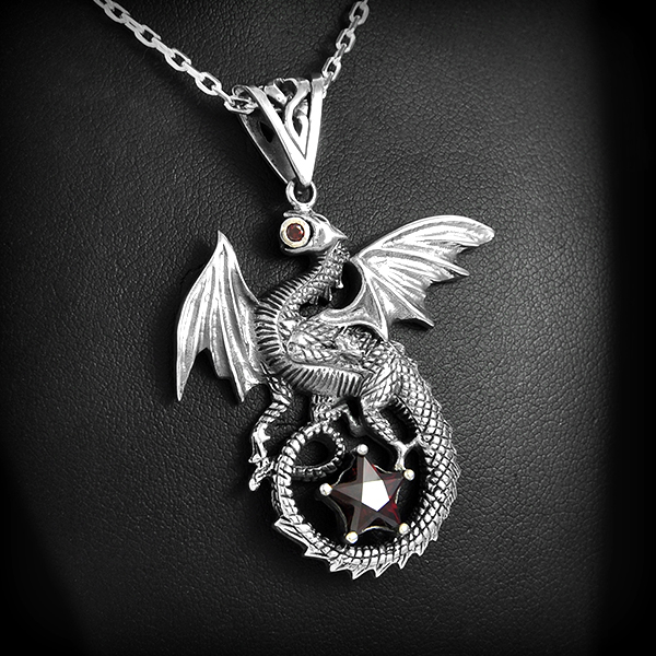 Superbe pendentif en argent d'un dragon aux ailes déployées tenant un petit zirconium dans sa...