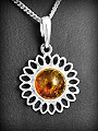 Pendentif d'une jolie petite marguerite en argent décorée d'une perle d'ambre de belle grosseur,...