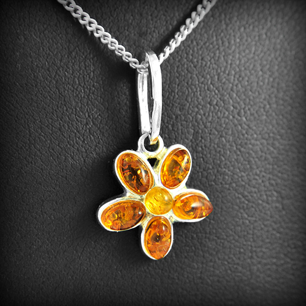Joli pendentif en argent d'une petite fleur ornée d'ambre couleur cognac et miel (h:24mm).