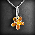 Joli pendentif en argent d'une petite fleur ornée d'ambre couleur cognac et miel (h:24mm).