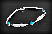 Très beau bracelet en argent composé de 4 plumes séparées par 3 petites turquoises reconstituées...