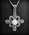 Superbe pendentif de style en argent d'une belle fleur baroque ornée d'une perle d'imitation au...