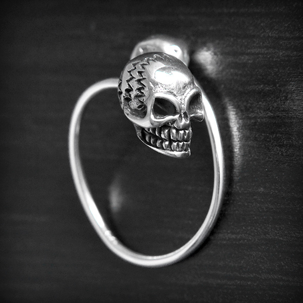 Bague ouverte en argent composée aux extrémités de deux têtes de mort "tête bêche" (h:11mm).