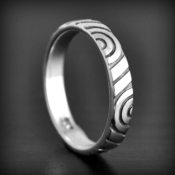 Bague en argent orné de motifs runiques par des cercles concentrique en quinconce (h:3mm).