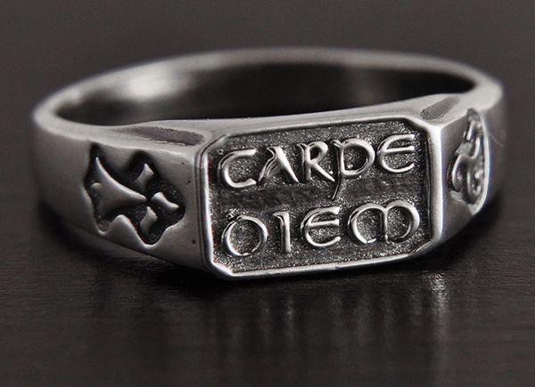 Belle bague en argent avec la célèbre formule "carpe diem" en relief sur la face, qui signifie...