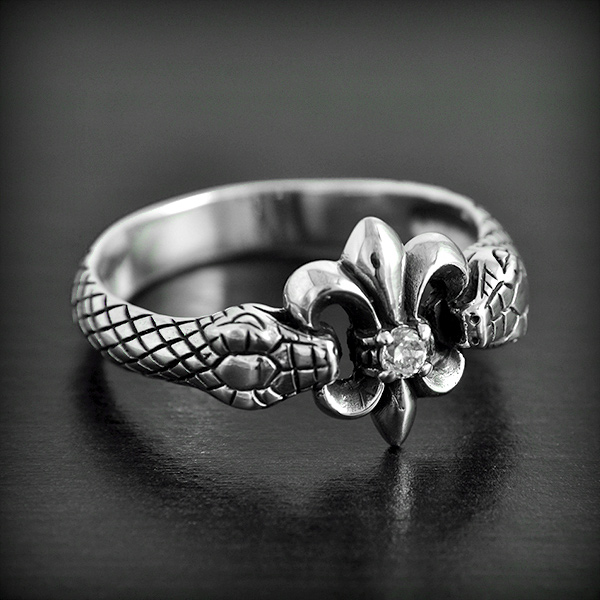 Bague originale en argent d'une jolie fleur de lys et zirconium blanc maintenue par deux serpents...