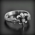 Bague originale en argent d'une jolie fleur de lys et zirconium blanc maintenue par deux serpents...