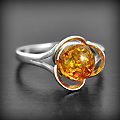 Bague en argent en forme de fleur moderne dont le centre est une perle d'ambre cognac ronde...