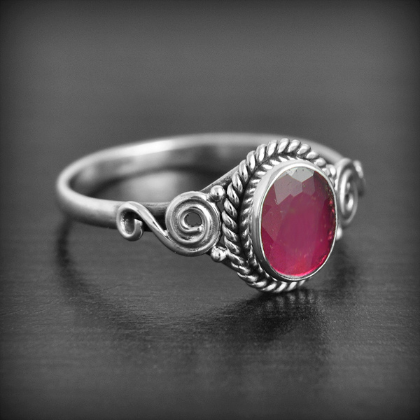 Bague en argent d'une belle pierre de Rubis facettée en cabochon joliment finie de spirales...