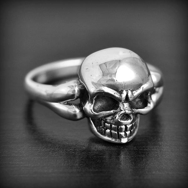 Bague en argent d'une belle tête de mort en volume dont la monture forme les os (h:15mm).