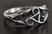 Bague celtique en argent d'un triskel ajouré, orné de fins dauphins sur les côtés constituant la...