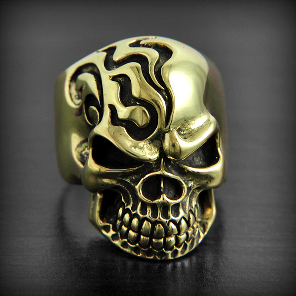 Bague en bronze d'une tête de mort de belle épaisseur, décorée de motifs tribaux sur la moitié...