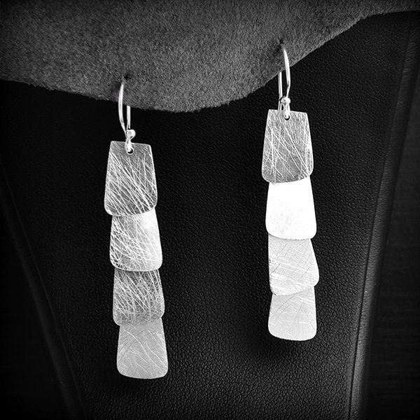 Élégante paire de boucles d'oreilles argent parées de fines tuiles en breloques et légèrement...