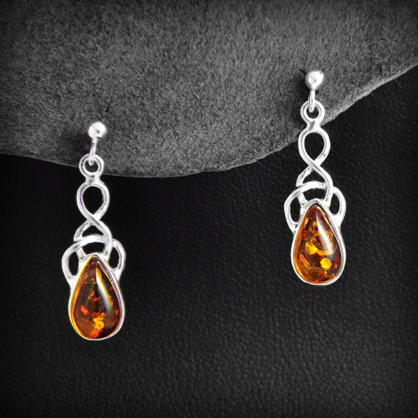 Jolie paire de boucles d'oreille en argent formée d'un entrelacs et paré d'une goutte d'ambre...