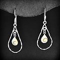 Boucles d'oreilles goutte en fil d'argent strié entourant un petit coquillage d'oeil de sainte...