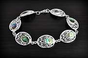Magnifique bracelet souple en argent constitué d'ovales ajourés et orné de nacre irisée abalone...