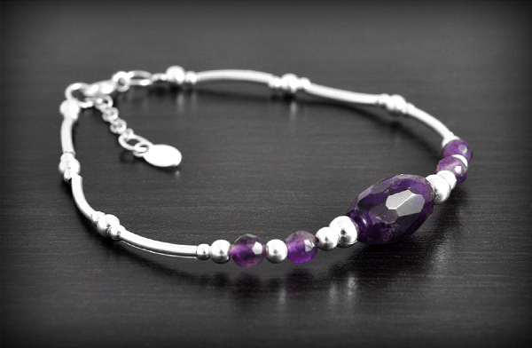 Élégant bracelet souple avec apprêts en argent et pierre d'améthyste dont la principale est...