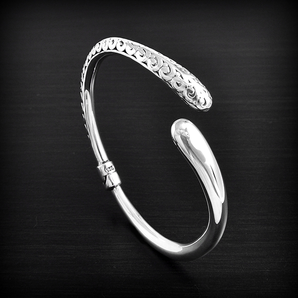 Ravissant bracelet rigide en argent orné d'un motif  floral art déco en relief juste d'un coté,...