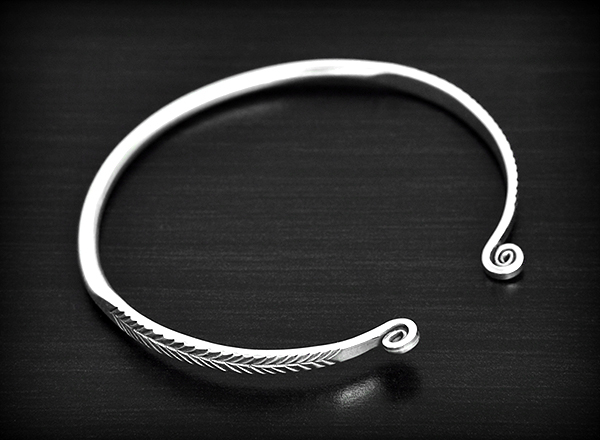 Bracelet en argent original, lisse sur le dessus et finition d'un petit feuillage enroulé (ep:3mm).