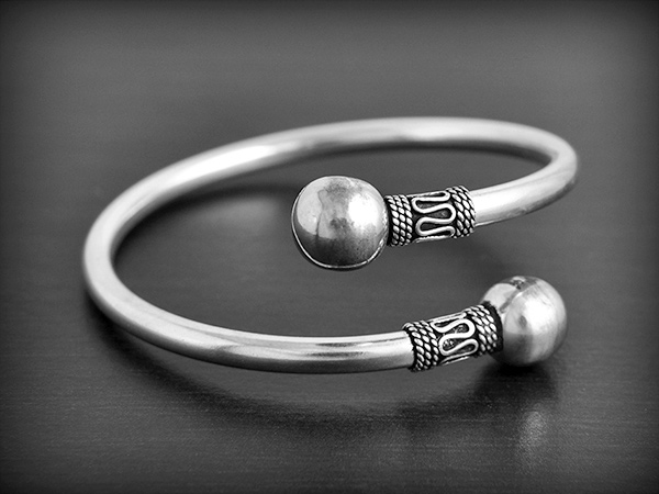Bracelet en argent creux ouvert, les deux extrémités sont décorées de motifs indonésiens et...