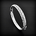 Superbe bracelet rigide en argent orné d'un motif tresse en relief, il est soufflé et donc creux...