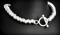 Magnifique bracelet en argent assez massif composé d'une multitude de disques enfilés, avec un...