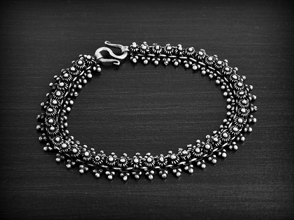 Bracelet ethnique souple en argent Pikun d'une rangée de fleurs de frangipanier bordée de...