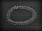 Bracelet ethnique souple en argent Pikun d'une rangée de fleurs de frangipanier bordée de...