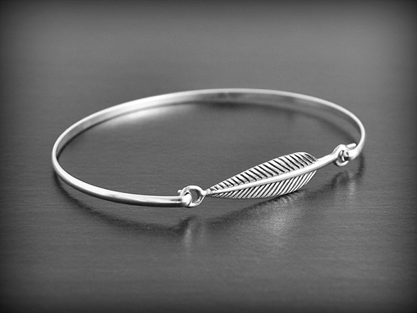 Bracelet en argent rigide d'une jolie plume et fermoir crochet(l:7mm, L:18cm).