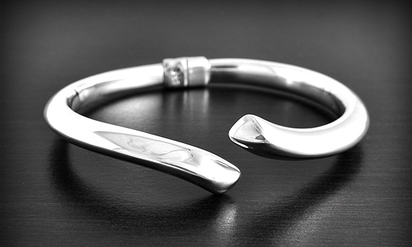 Ravissant bracelet rigide et creux en argent de style contemporain en un lacet biseauté ouvert...