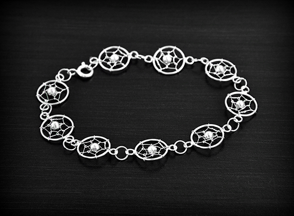 Joli bracelet en argent composé de petits attrapes rêves ornés d'une petite perle au centre...