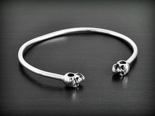 Bracelet rigide en argent, tube massif avec en finition, deux crânes (ep:3mm).