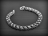 Joli bracelet en argent avec une maille décorée de deux rangées de petites fleurs de frangipanier...