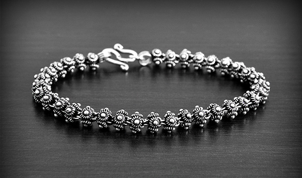 Superbe bracelet souple en argent constitué d'une rangée de fleurs de frangipanier sur 4 faces....