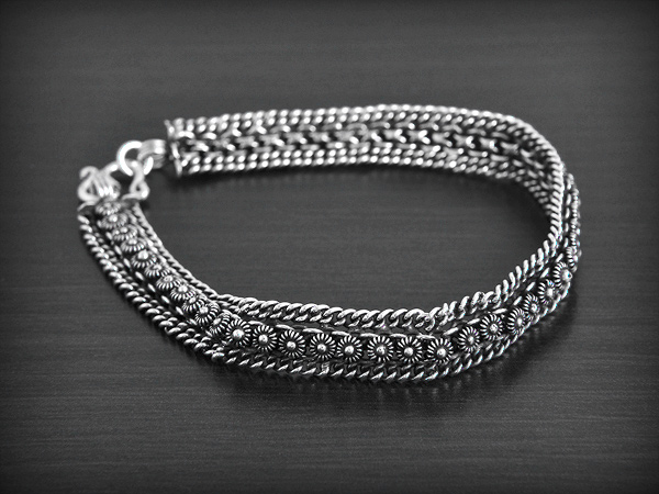 Superbe bracelet en argent avec une maille constituée d'une rangée double de petites fleurs en...