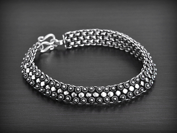 Ravissant bracelet souple en argent composé de 3 rangées de petites fleurs alternées de petits...