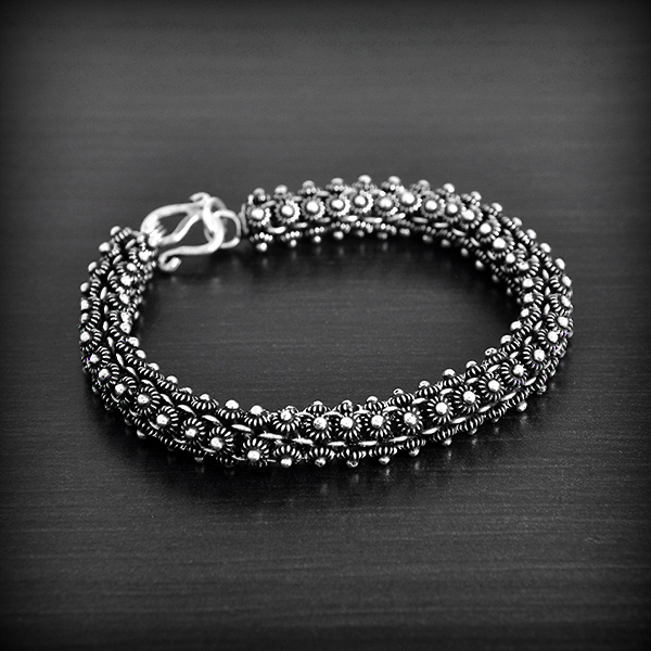 Très joli bracelet souple en argent composé de 4 rangées de fleurs de frangipanier, avec fermoir...