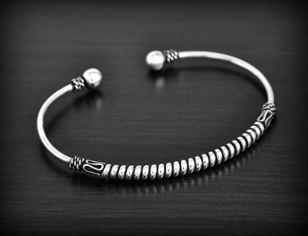 Bracelet esclave rigide en argent orné d'une torsade ethnique indonésienne, terminé par une boule...
