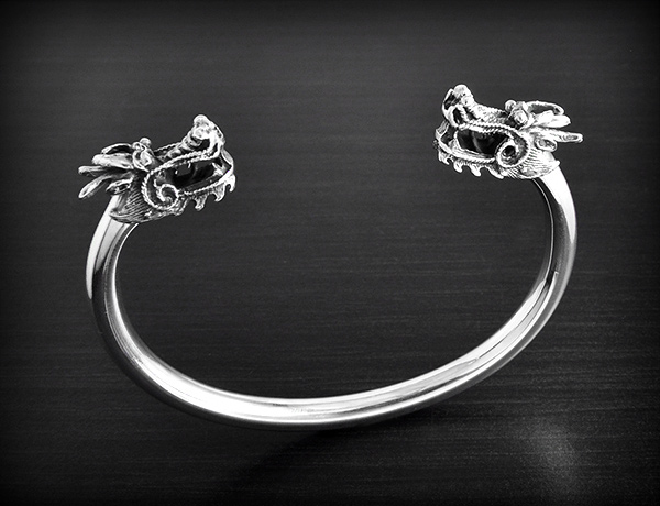 Superbe bracelet ouvert rigide en argent orné d'une tête de dragon en volume à chaque extrémité...