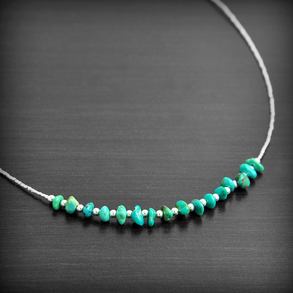 Collier fil d' argent avec au centre de petites pierres de Turquoise de forme baroque alternées...